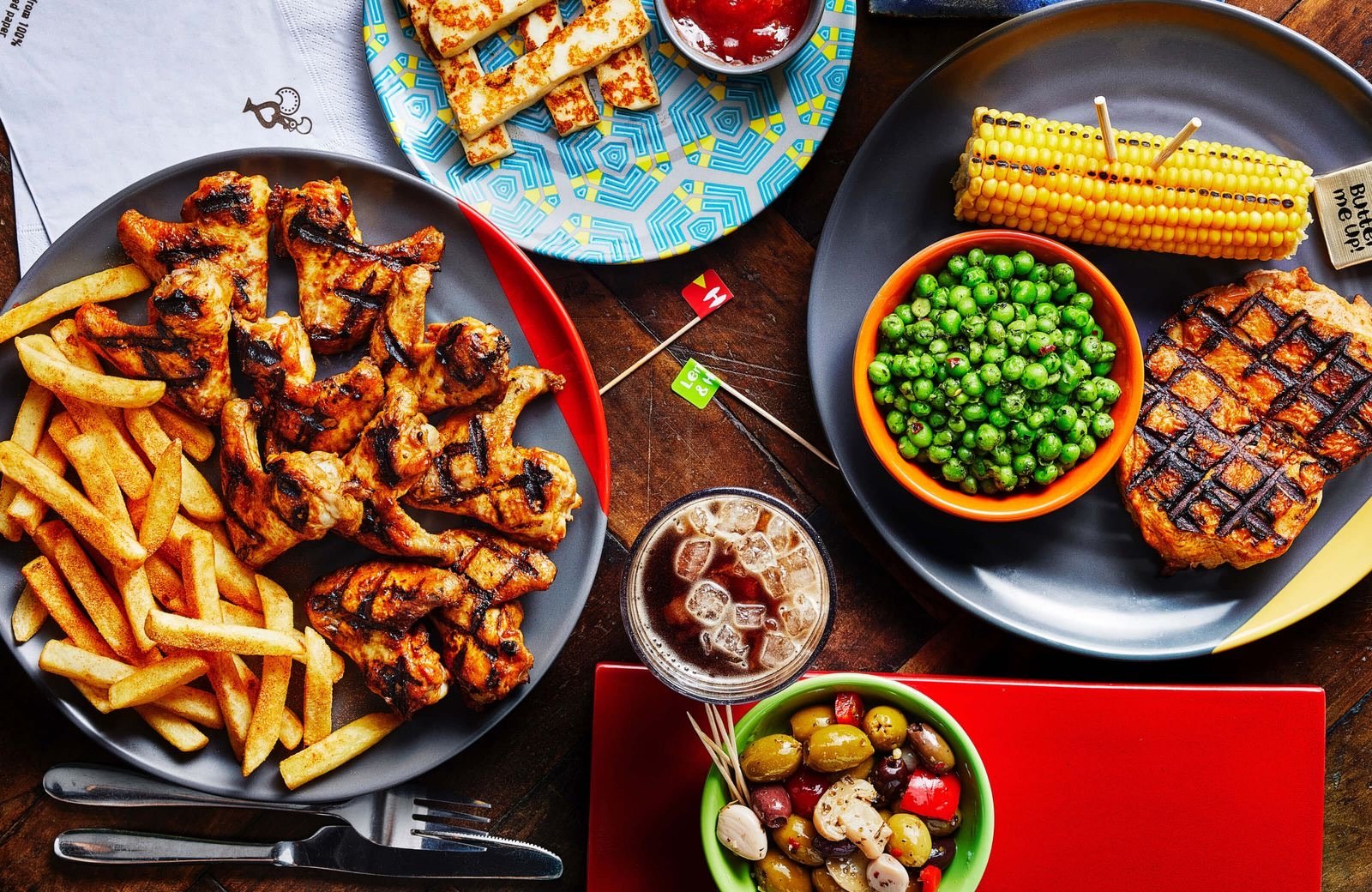 A table spread with Nando's peri-peri chicken, sides, drinks and sauces